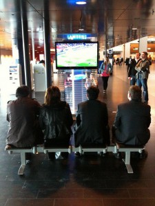 Four people in front of a television in Stockholm Airport